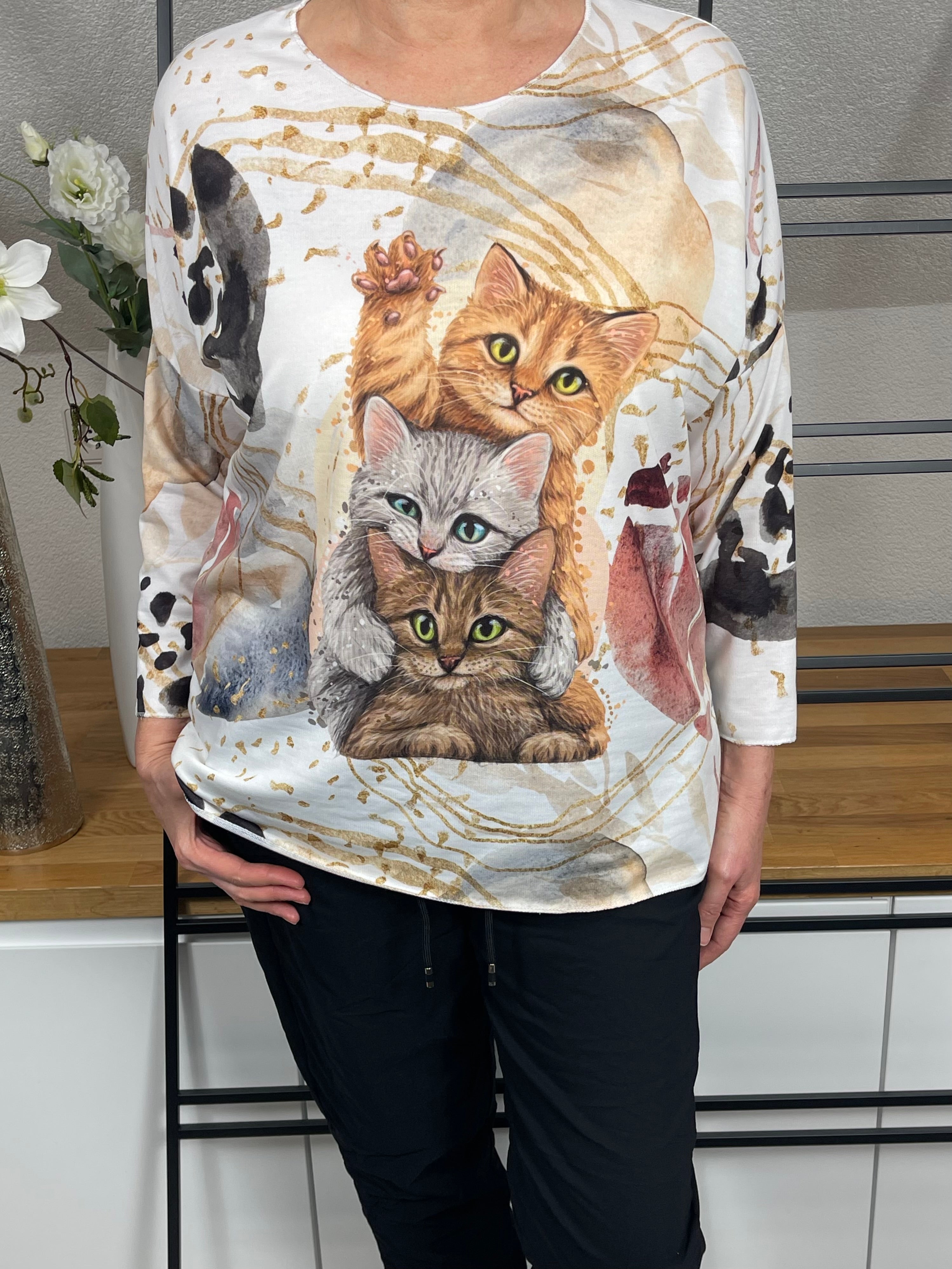 Detailansicht des bunten Katzenmotivs auf dem weißen Feinstrickpullover für Damen